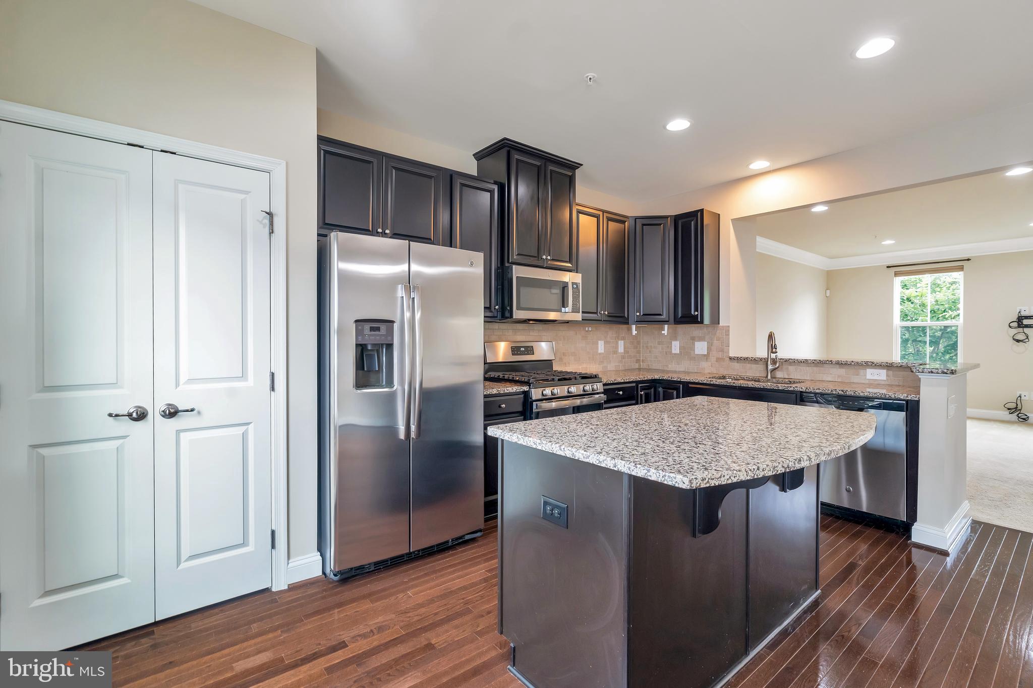 102 Patriots Path Malvern, PA 19355 - Photo 2 of 30 a kitchen with stainless steel appliances granite countertop a refrigerator a sink and wooden cabinets