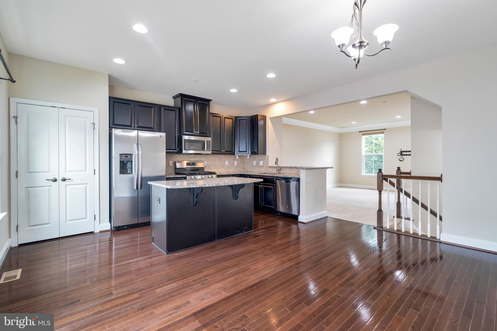 102 Patriots Path Malvern, PA 19355 - Photo 3 of 30 a kitchen with stainless steel appliances kitchen island wooden floors wooden cabinets and refrigerator