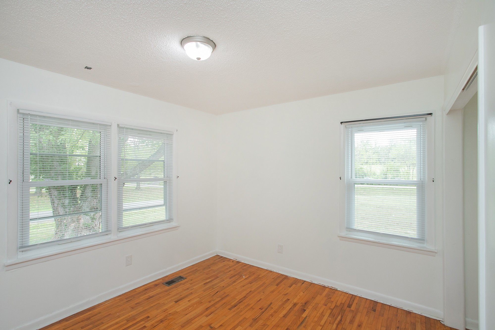 129 Poplar Street Eagleville, TN 37060 - Photo 18 of 23 an empty room with wooden floor and windows