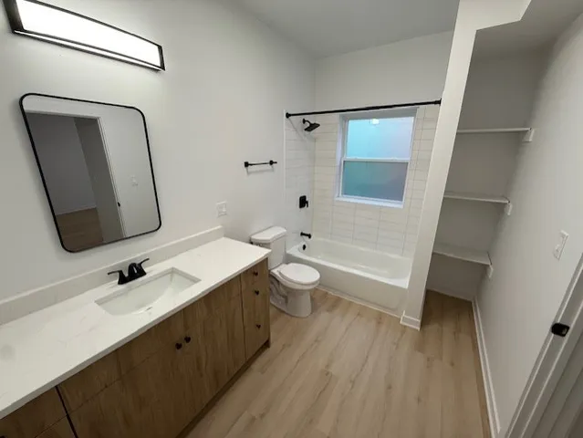 a bathroom with a double vanity sink toilet mirror and shower