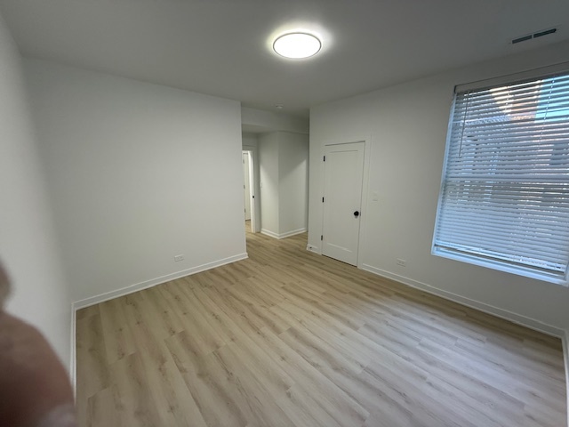 7717 North Sheridan Road, Unit 3R Chicago, IL 60626 - Photo 9 of 17 wooden floor in an empty room with a window