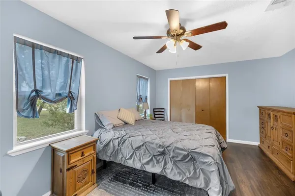 a bedroom with a bed a flat tv screen and dresser