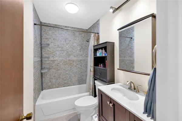 a bathroom with a granite countertop sink toilet and shower