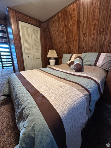 1085 West Elk Road Helper, UT 84526 - Photo 20 of 40 Room featuring wood-finish paneling, louvered bi-fold closet doors, and sloped ceilings