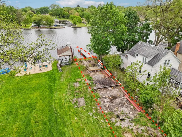 an aerial view of house with yard and lake view
