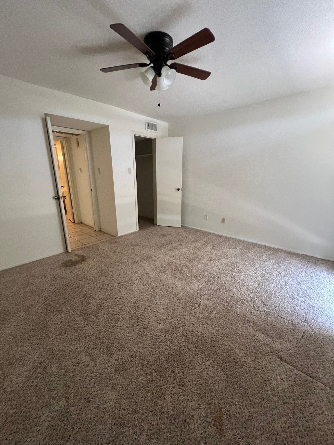 4631 Wild Indigo Street, Unit 572 Houston, TX 77027 - Photo 12 of 13 an empty room with a ceiling fan and a window