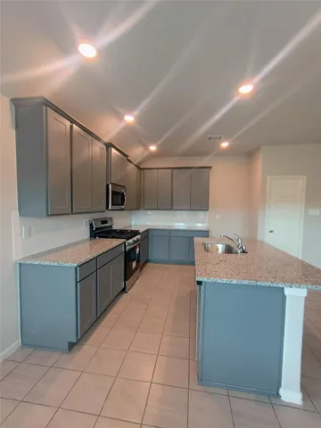 a large kitchen with stainless steel appliances lots of counter top space