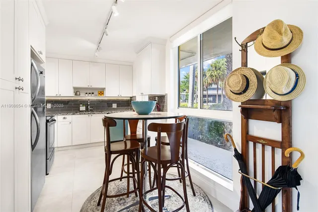 a kitchen with stainless steel appliances granite countertop a stove a refrigerator a microwave oven with a dining table and chairs