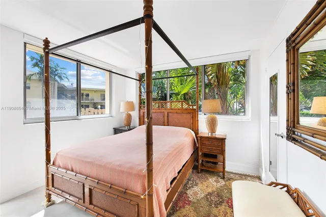 a bedroom with a bed window and a flat tv screen