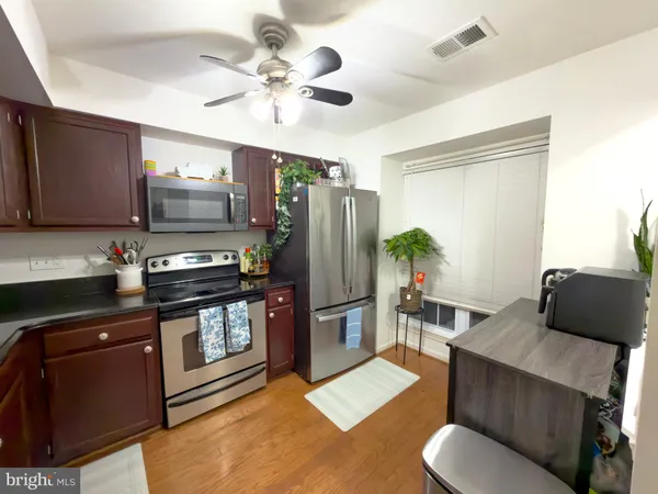 a kitchen with stainless steel appliances granite countertop a refrigerator a sink a stove with cabinets