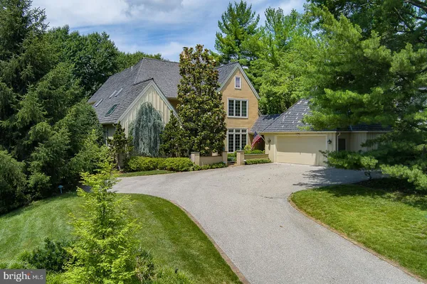 a view of a house with backyard and bushes