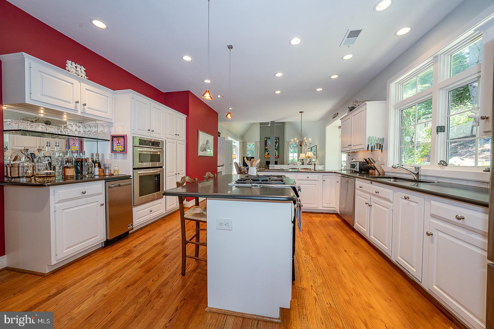 1241 Denbigh Lane Wayne, PA 19087 - Photo 37 of 94 a kitchen with stainless steel appliances kitchen island granite countertop wooden floors and white cabinets