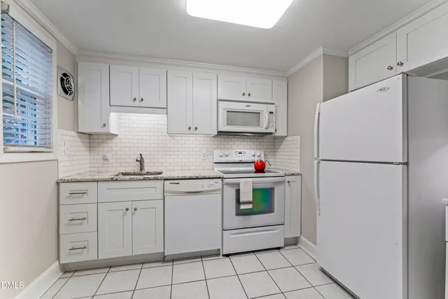 a kitchen with white cabinets and white appliances