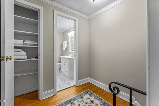 a view of a hallway with wooden floor and closet