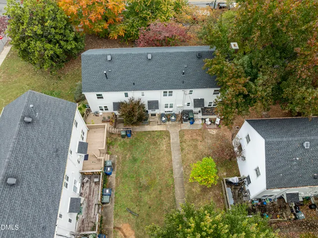 a front view of a house with garden space and trees all around