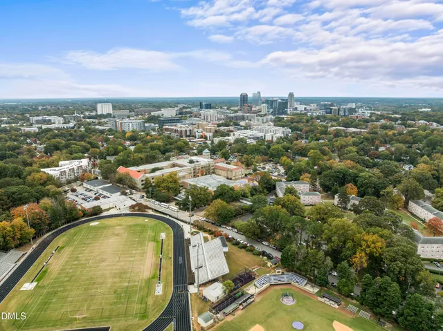 an aerial view of residential houses with outdoor space and trees
