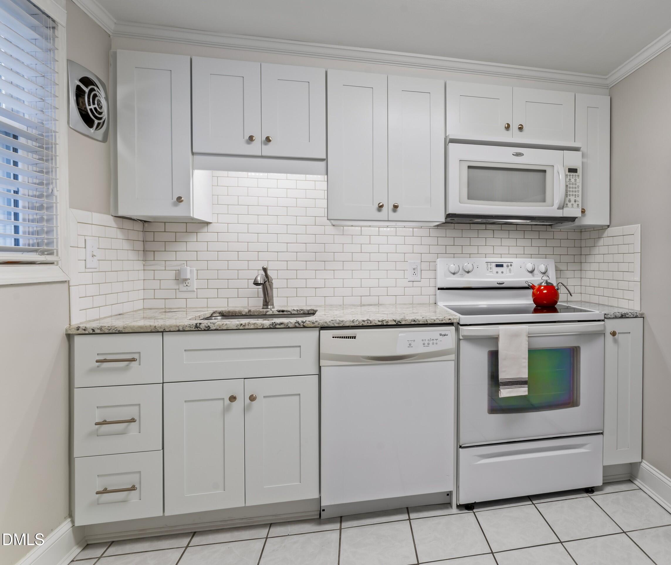 715 Wade Avenue Raleigh, NC 27605 - Photo 5 of 41 a kitchen with white cabinets and white appliances