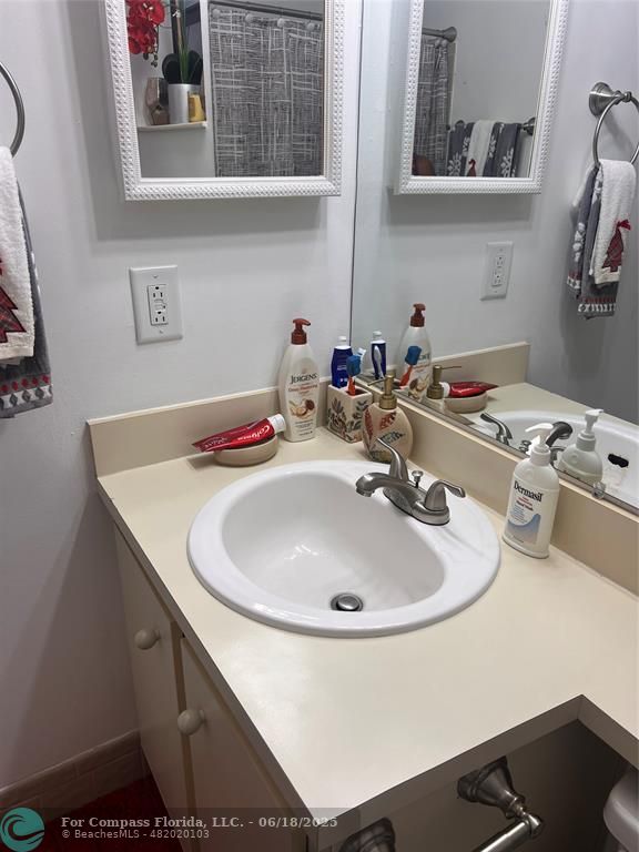 3461 Cocoplum Circle, Unit 3431 Coconut Creek, FL 33063 - Photo 9 of 16 a bathroom with a sink and a mirror