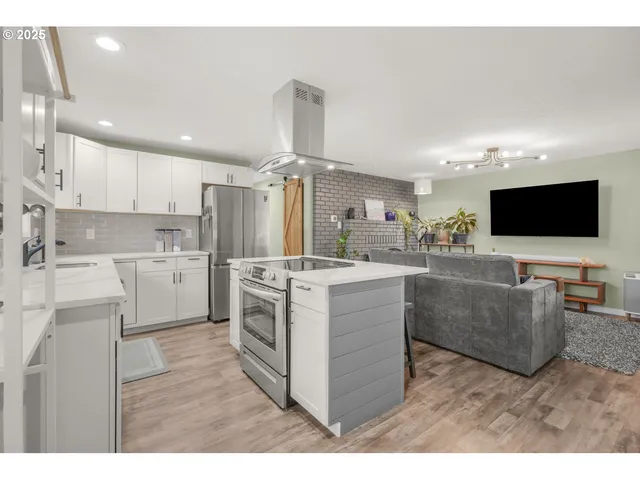 a kitchen with cabinets a sink and a stove top oven with wooden floor