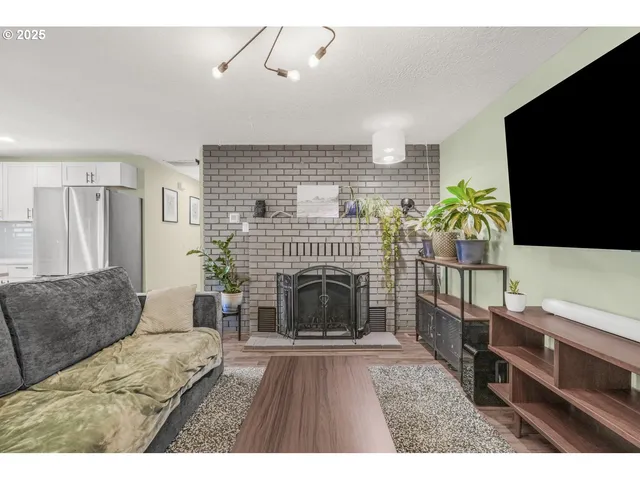 a living room with furniture a flat screen tv and a fireplace