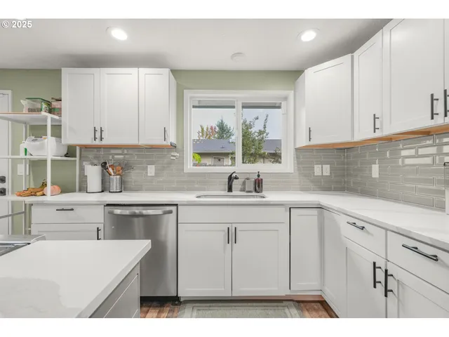 a kitchen with cabinets appliances a sink and a window