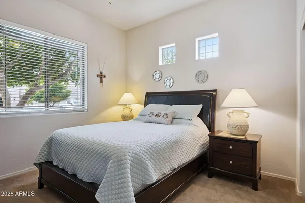 a bedroom with a bed and a mirror on dresser