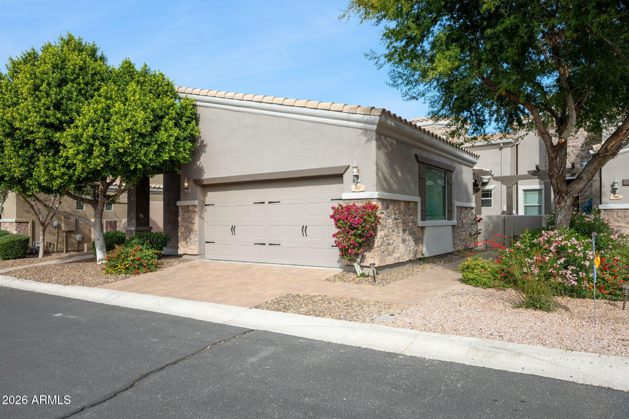 6202 East McKellips Road, Unit 107 Mesa, AZ 85215 - Photo 3 of 32 a front view of a house with a yard and a garage