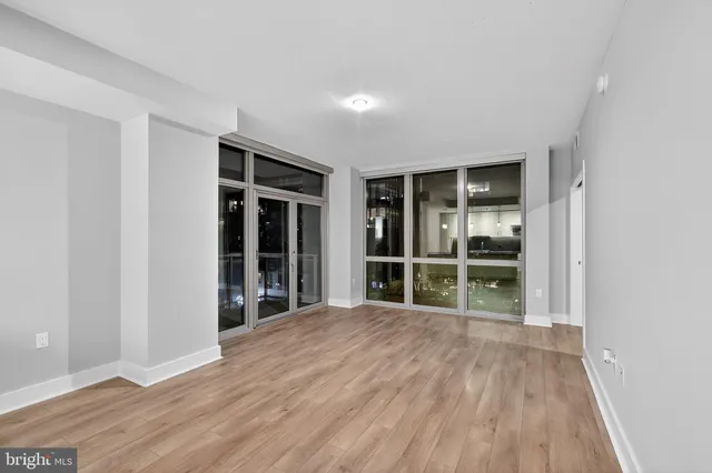 a view of empty room with wooden floor and window