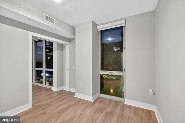 an empty room with wooden floor and entrance