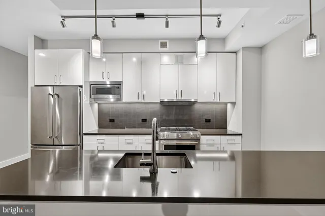 a kitchen with kitchen island white cabinets and refrigerator