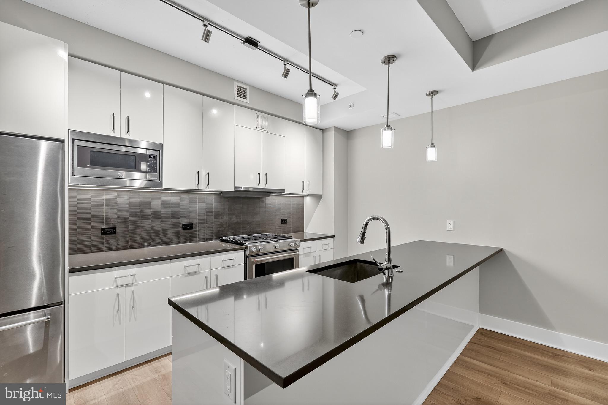 88 V Street Southwest, Unit 509 Washington, DC 20024 - Photo 5 of 36 a kitchen with stainless steel appliances granite countertop a sink a refrigerator and a stove