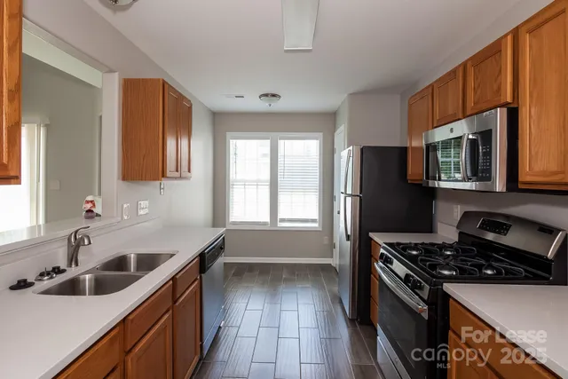 a kitchen that has a sink cabinets counter space and stainless steel appliances