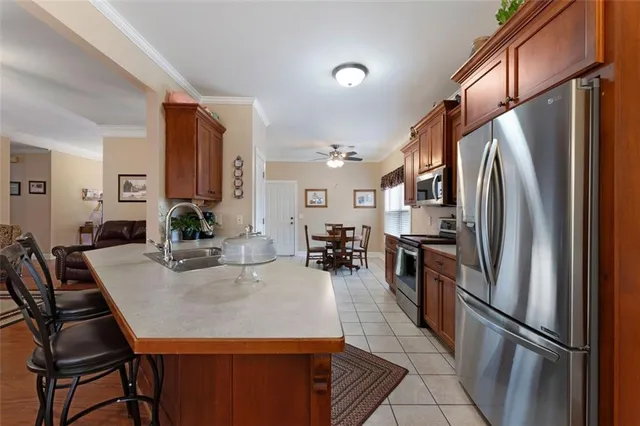 a kitchen with stainless steel appliances granite countertop a refrigerator a stove a sink a dining table and chairs