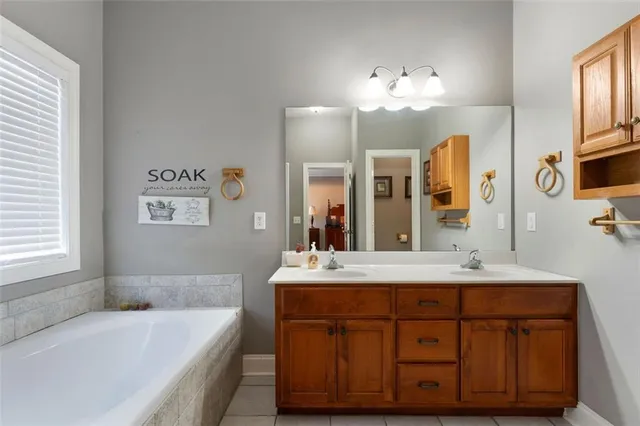 a bathroom with a sink double vanity granite tub and a mirror