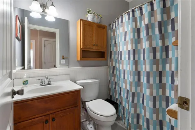 a bathroom with a sink a toilet and shower curtain