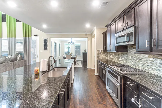 a large kitchen with stainless steel appliances granite countertop plenty wooden cabinets counter space a sink and a stove