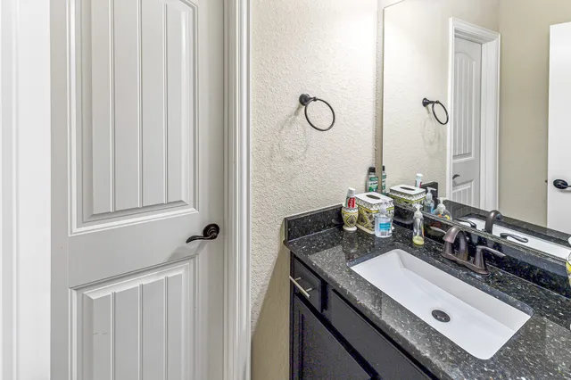 a bathroom with a granite countertop sink and a mirror