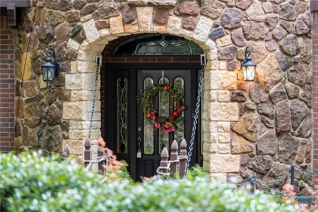 a walk in closet with wooden floor