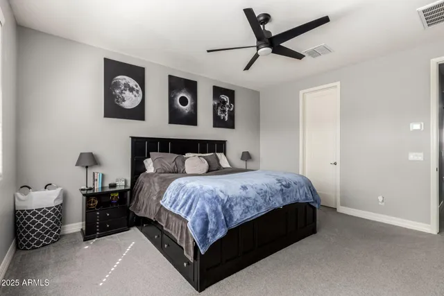 a bedroom with a bed and painting on the wall