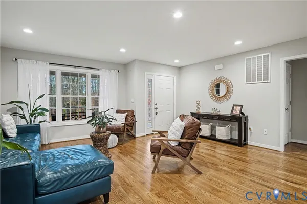 a view of a a dining room with furniture window and wooden floor