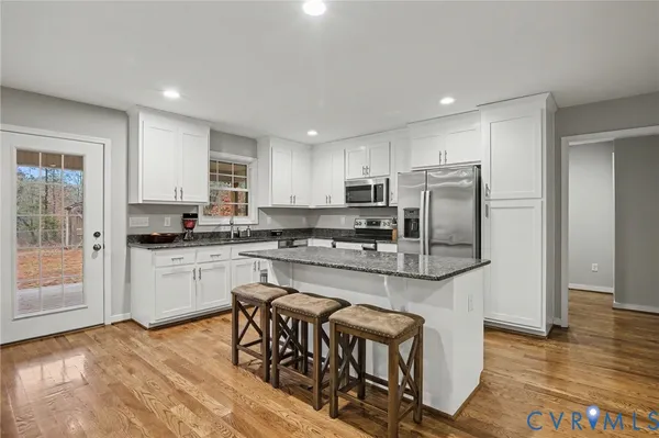 a kitchen with granite countertop a stove sink and microwave