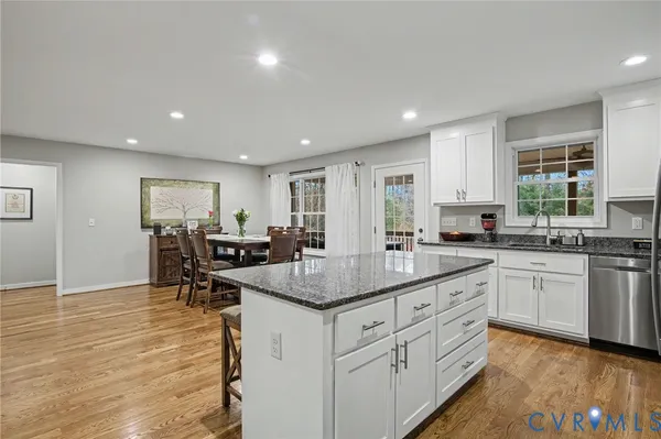a kitchen with white cabinets sink and stove