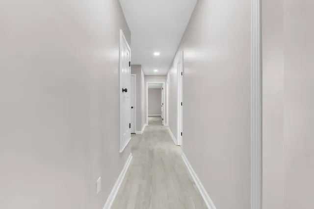 a view of a hallway with wooden floor