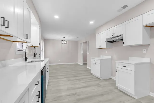 a kitchen with a sink stove and cabinets