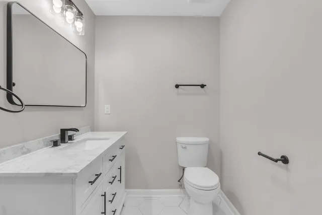 a bathroom with a toilet a sink and mirror