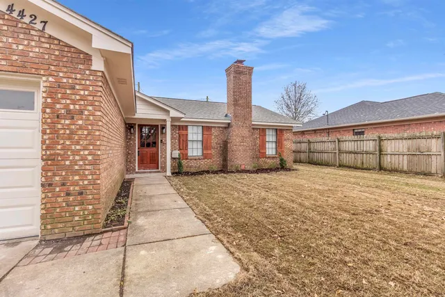 a view of a house with a backyard