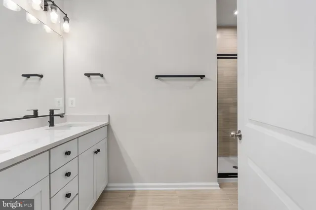 a bathroom with a granite countertop sink and mirror