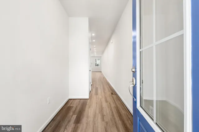 a view of a hallway with wooden floor and staircase