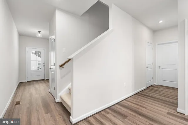 a view of a hallway with wooden floor and entryway