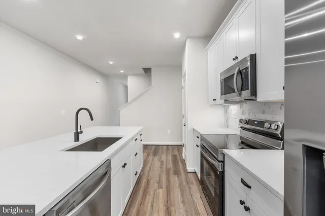 a kitchen with stainless steel appliances granite countertop a sink and stove top oven